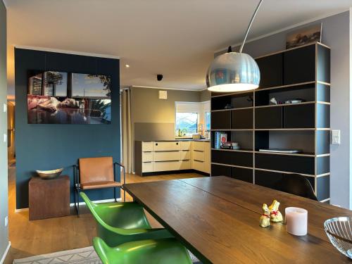 une salle à manger avec une table en bois et des chaises vertes dans l'établissement großzügiges Luxusappartement 106qm - Dachterrasse, à Bad Aibling