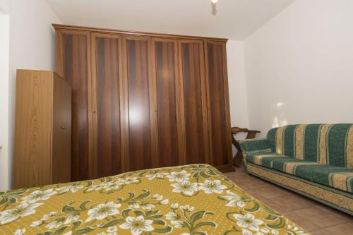 a bedroom with a bed and a wooden cabinet at Farmstay Agriturismo La Fonte in Belforte del Chienti