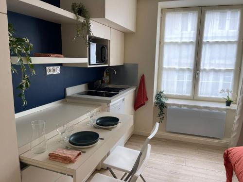 Una cocina con una mesa y sillas y un fregadero. en Comme une chambre d’hôtel au cœur de Lyon, en Lyon