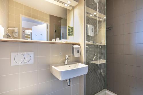uma casa de banho com um lavatório e um chuveiro em B&B HOTEL Lyon Aéroport Saint-Quentin-Fallavier em Saint-Quentin-Fallavier