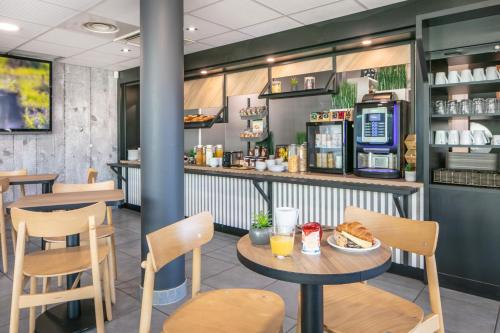 een fastfoodrestaurant met een tafel en stoelen bij B&B HOTEL Lyon Aéroport Saint-Quentin-Fallavier in Saint-Quentin-Fallavier