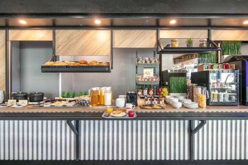 a buffet line with food on a counter at B&B HOTEL Lyon Aéroport Saint-Quentin-Fallavier in Saint-Quentin-Fallavier
