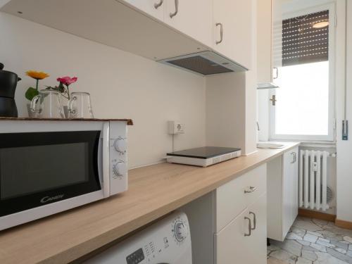 a kitchen with a counter with a microwave on it at Xenia Apartments - Spacious two-room apt in the flower district in Milan