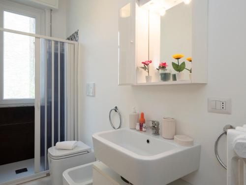 a white bathroom with a sink and a toilet at Xenia Apartments - Spacious two-room apt in the flower district in Milan