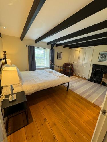 a bedroom with a large bed and a fireplace at Woodbine Cottage in Studdon