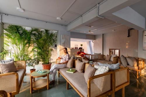 two people sitting on a couch in a living room at Hotel Tattva Suites in Pune