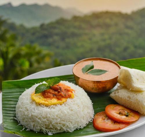 a plate of rice and bread on a banana leaf at Cloudy Cove Resort in Meppādi