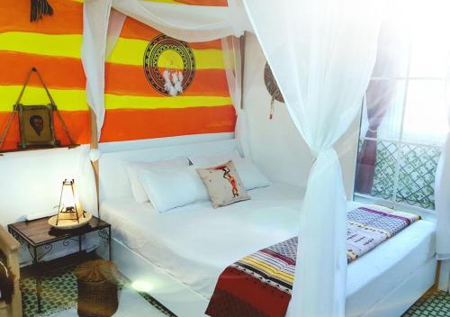 a small room with a bed with a canopy at The African Story in La Marsa