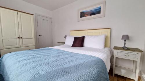 a bedroom with a bed with a blue and white comforter at 5 The Burrows in Braunton