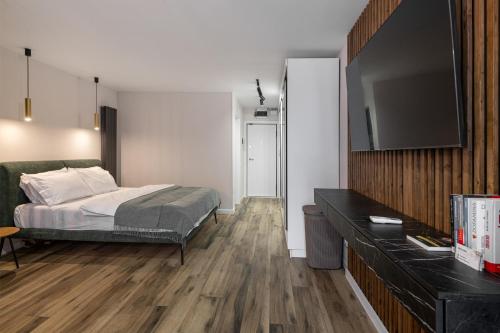 Moon Apartments في كلوي نابوكا: غرفة نوم بها سرير وتلفزيون بشاشة مسطحة