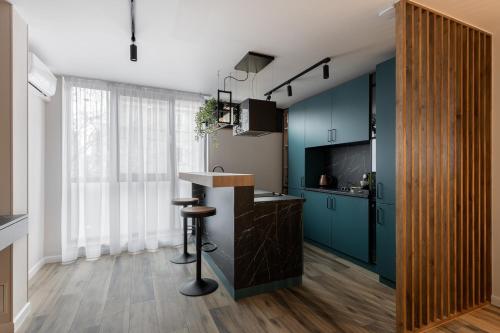 een keuken met blauwe kasten en een aanrecht bij Moon Apartments in Cluj-Napoca
