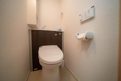 a bathroom with a toilet and a toilet paper dispenser at shinjuku1 in Tokyo