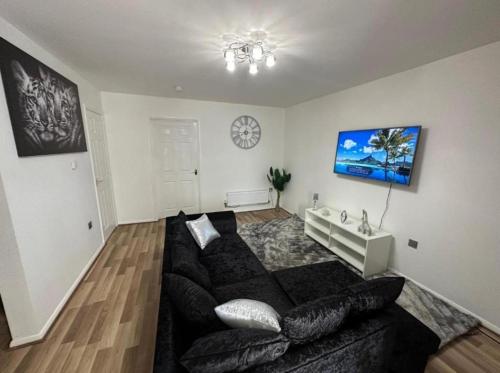 a living room with a couch and a tv at Stunning 3-Bed House in Manchester in Manchester