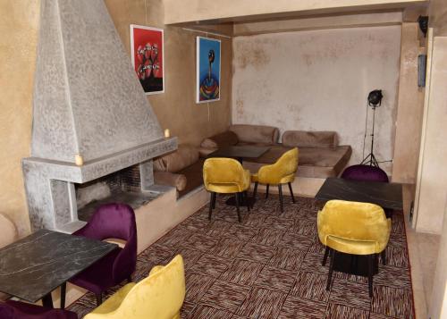 a living room with yellow chairs and a fireplace at L'Oum Errebia in Azemmour