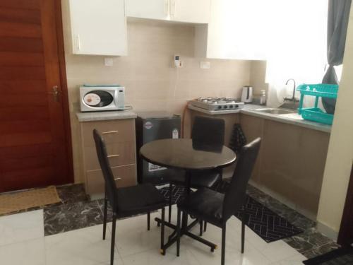 une petite cuisine avec une table et des chaises. dans l'établissement Studio Apartment Nyali, à Mombasa