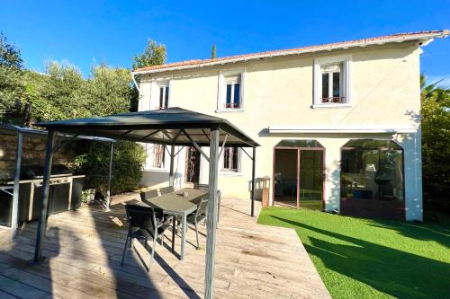 - une table et des chaises sous un parasol sur la terrasse dans l'établissement Golfe Juan - Villa 4 people - Sea view - Garden, à Vallauris