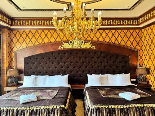 a hotel room with two beds and a chandelier at Royal SPA & Hotel Resort in Rīga