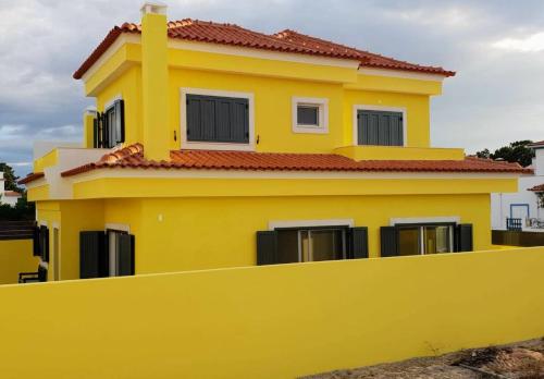 a yellow house behind a yellow fence at Holidays Home Comporta in Comporta