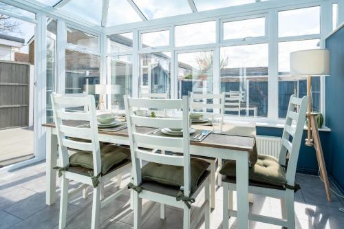 a white dining room with a table and chairs at Gatwick Place - 4 bed 2 bath self contained house with private garden in Horley