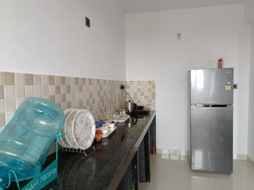 a kitchen with a counter and a refrigerator at Zanita Heights Seaview Apt in Bogmalo