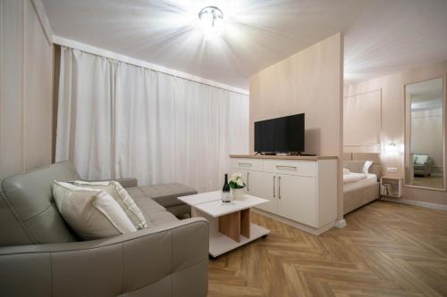 a living room with a couch and a tv at Monako in Kłodzko