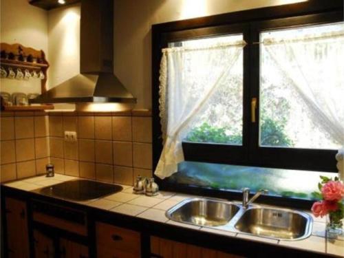 een keuken met een wastafel en een raam bij El Olivar in Palo