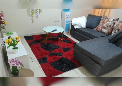 a living room with a couch and a red and black rug at Shansline Guest House in Nairobi