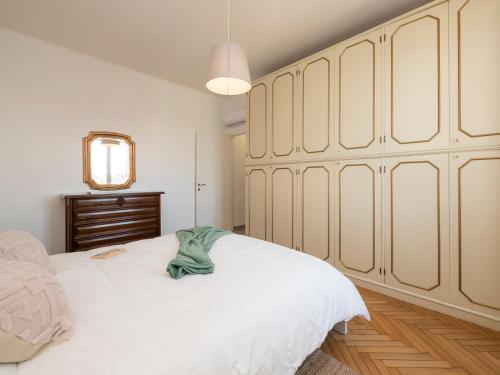 una camera da letto con un grande letto bianco e uno specchio di Xenia Apartments - Newly renovated apartment a Milano