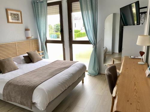 a bedroom with a bed and a large window at Logis Hotel Restaurant l'Orée Des Bois in La Breille-les-Pins