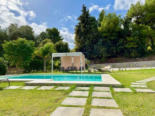 una piscina in un cortile con tenda di Strelitzia's house with pool, parking & wi-fi ad Avola
