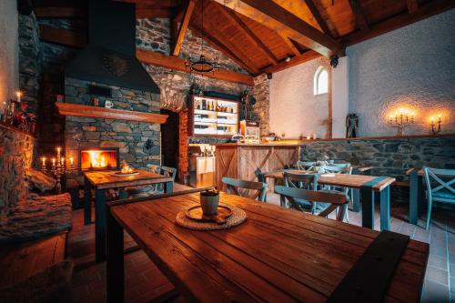 a restaurant with a wooden table and a fireplace at Hrad Kunzov Glamping & SPA & Restaurant in Přerov