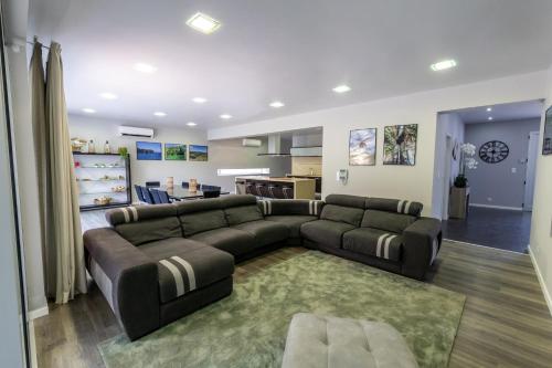 a living room with a large couch and a kitchen at Luxury Villa in Ribeira Grande in Ribeira Grande