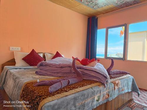 a bedroom with a bed with two animals on it at Wanderlust Cottage Pangong Lake, Lukung, in Lukung