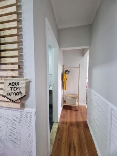 a hallway with white walls and wood floors at Loft no Butantã, próximo a USP in Sao Paulo