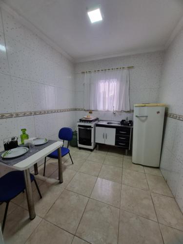 uma pequena cozinha com uma mesa e um frigorífico em Loft no Butantã, próximo a USP em São Paulo