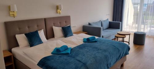 a bedroom with a large bed with blue pillows on it at Villa Le Lux in Mikołajki