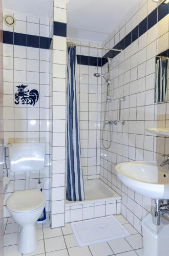 a bathroom with a toilet and a tub and a sink at APPART-HÔTEL MARCO POLO in Luxembourg