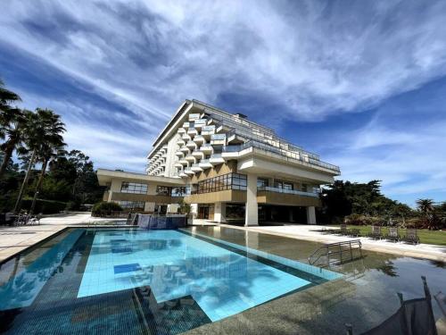 a large building with a swimming pool in front of it at Apartamento Vista Ponte in Niterói