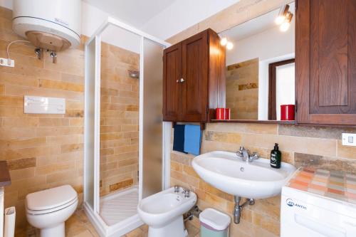 een badkamer met een toilet, een wastafel en een douche bij Rosmarino Apartment in Garda