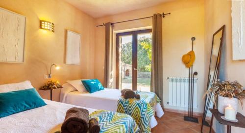 1 Schlafzimmer mit 2 Betten und einem Fenster in der Unterkunft Na Berganta in Artá