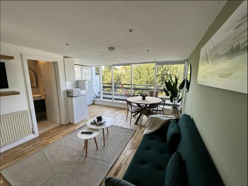een woonkamer met een bank en een tafel bij Primrose Hill Apartment with Balcony in Londen