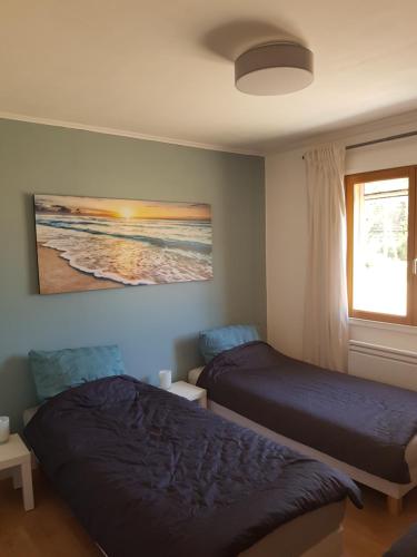 a bedroom with two beds and a window and a painting at Villa mit großartigem Panoramablick auf das Meer und direkt am Pool in La Croix-Valmer