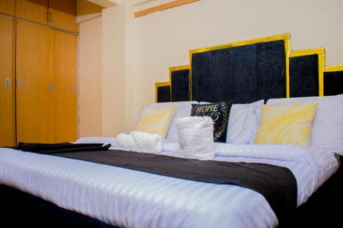 a large bed with towels on top of it at G&G Homes Executive 2 bedroom Town Apartment in Eldoret