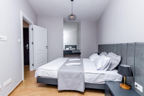 布德瓦Apartman DELUXE的一间卧室，里面有一张铺着白色床单的大床。