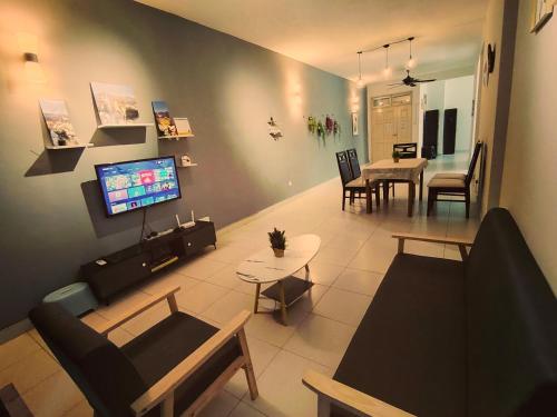 ein Wohnzimmer mit einem Sofa, einem TV und einem Tisch in der Unterkunft JB Tebrau Staycation City Walk Within 6 mins to Ikea Toppen & AEON Mall in Johor Bahru