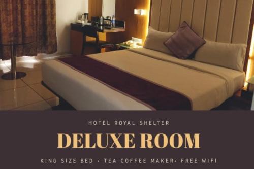 a bed in a hotel room with a sign that reads deluge room at Hotel Royal Shelter Vapi in Vapi