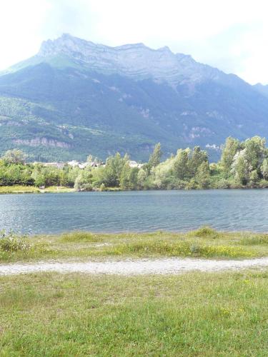 a large body of water with a mountain in the background at Ô & Cimes in Saint-Pierre-dʼAlbigny