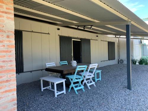 een patio met een houten tafel en 4 stoelen bij CANDELA casa en balneario Los Pinos II in Fomento