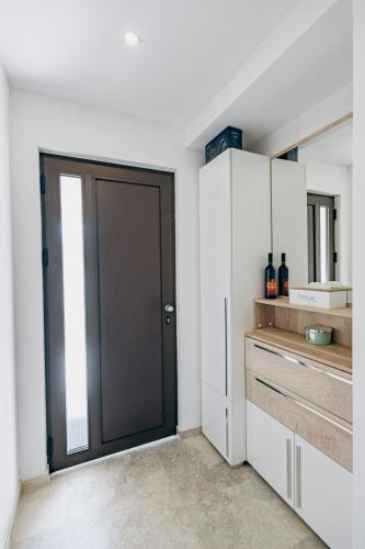 a black door in a kitchen with white cabinets at Bečići lux in Bečići