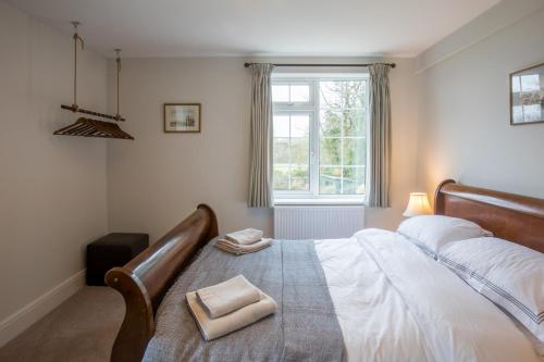 a bedroom with a bed with two towels on it at Peaceful Woodland Retreat near Clifton, Bristol in Bristol